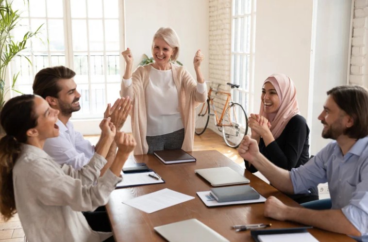 Leidinggevende die positiviteit en betrokkenheid stimuleert tijdens een teammoment in een kmo omgeving.